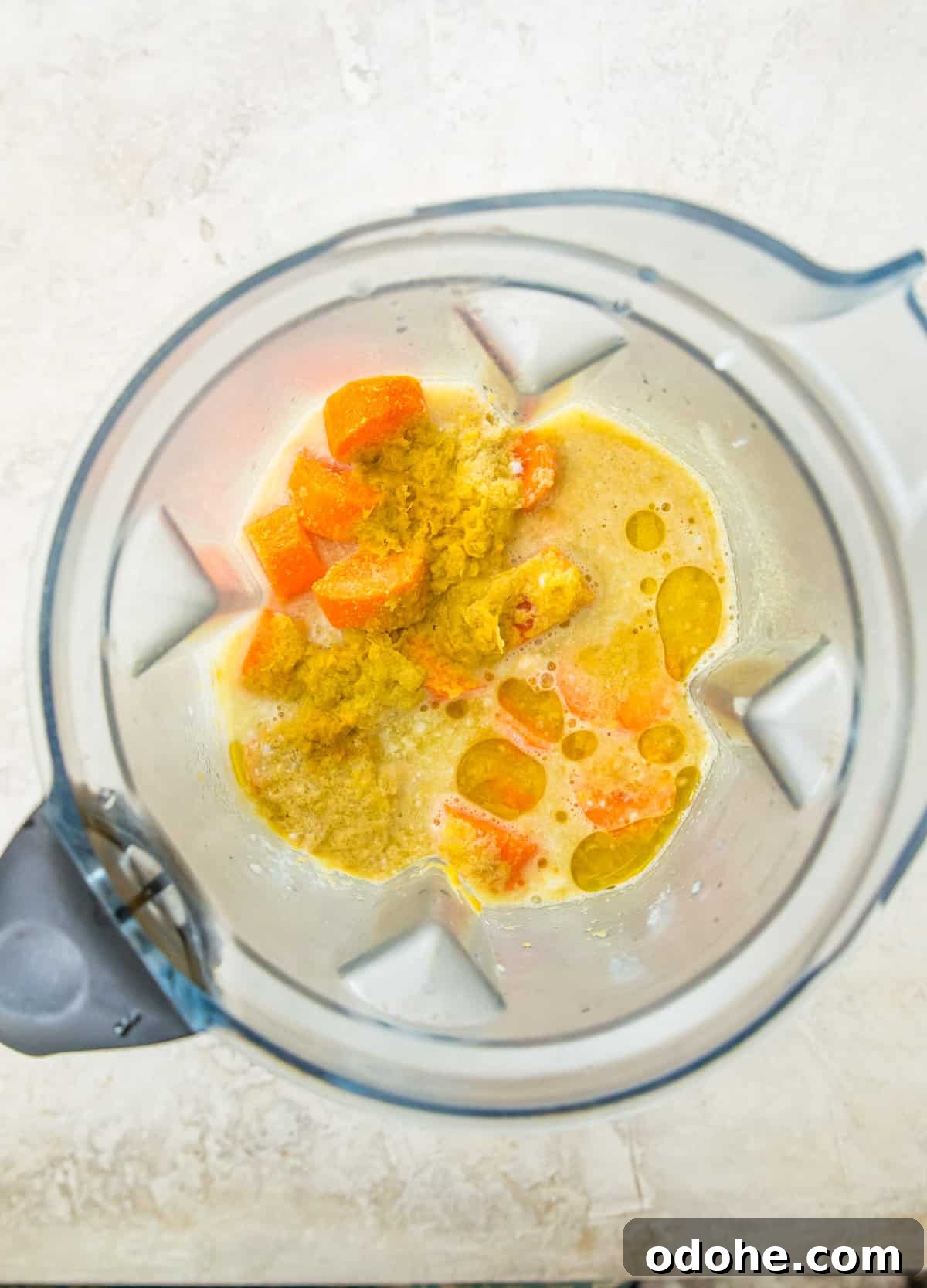 A blender with chopped carrots and water in it.