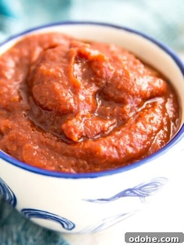 A bowl of bbq sauce with a blue tea towel around it.