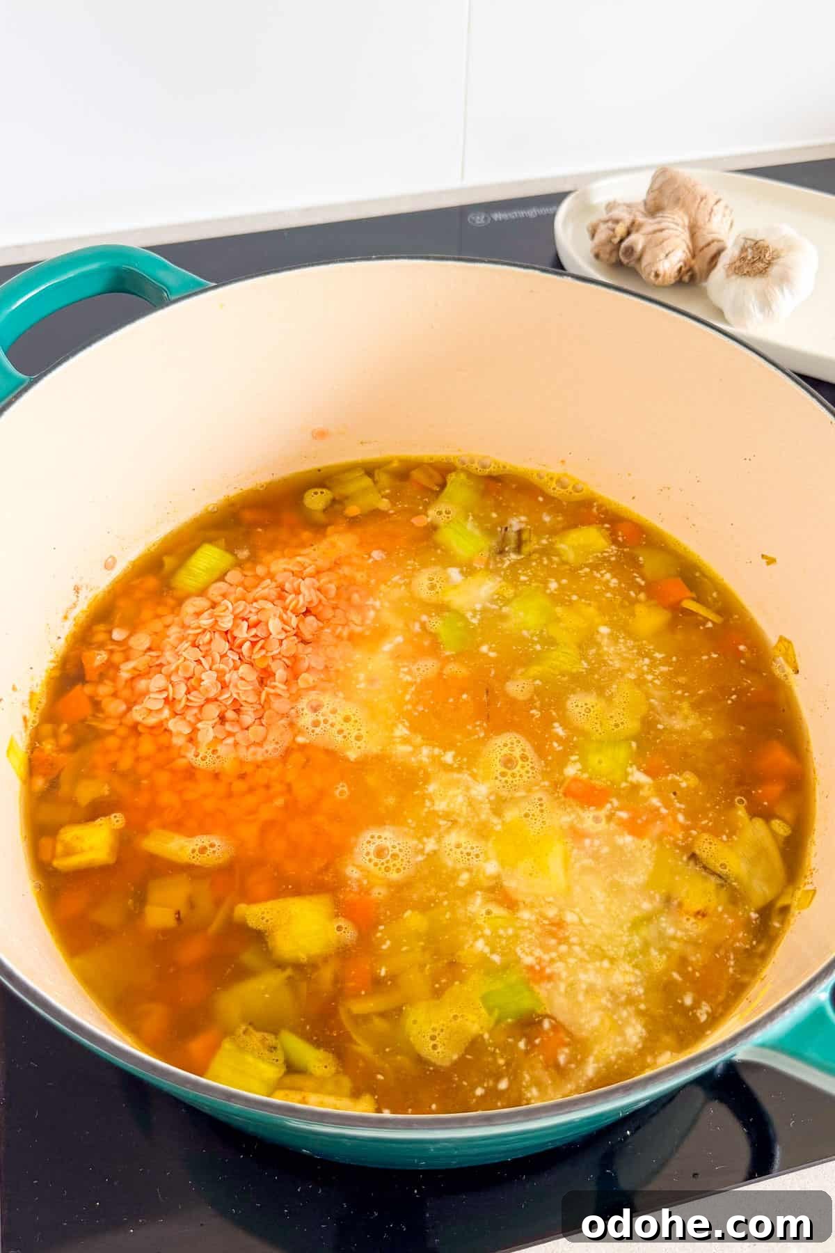 Dried lentils, coconut milk and broth added to the pot.
