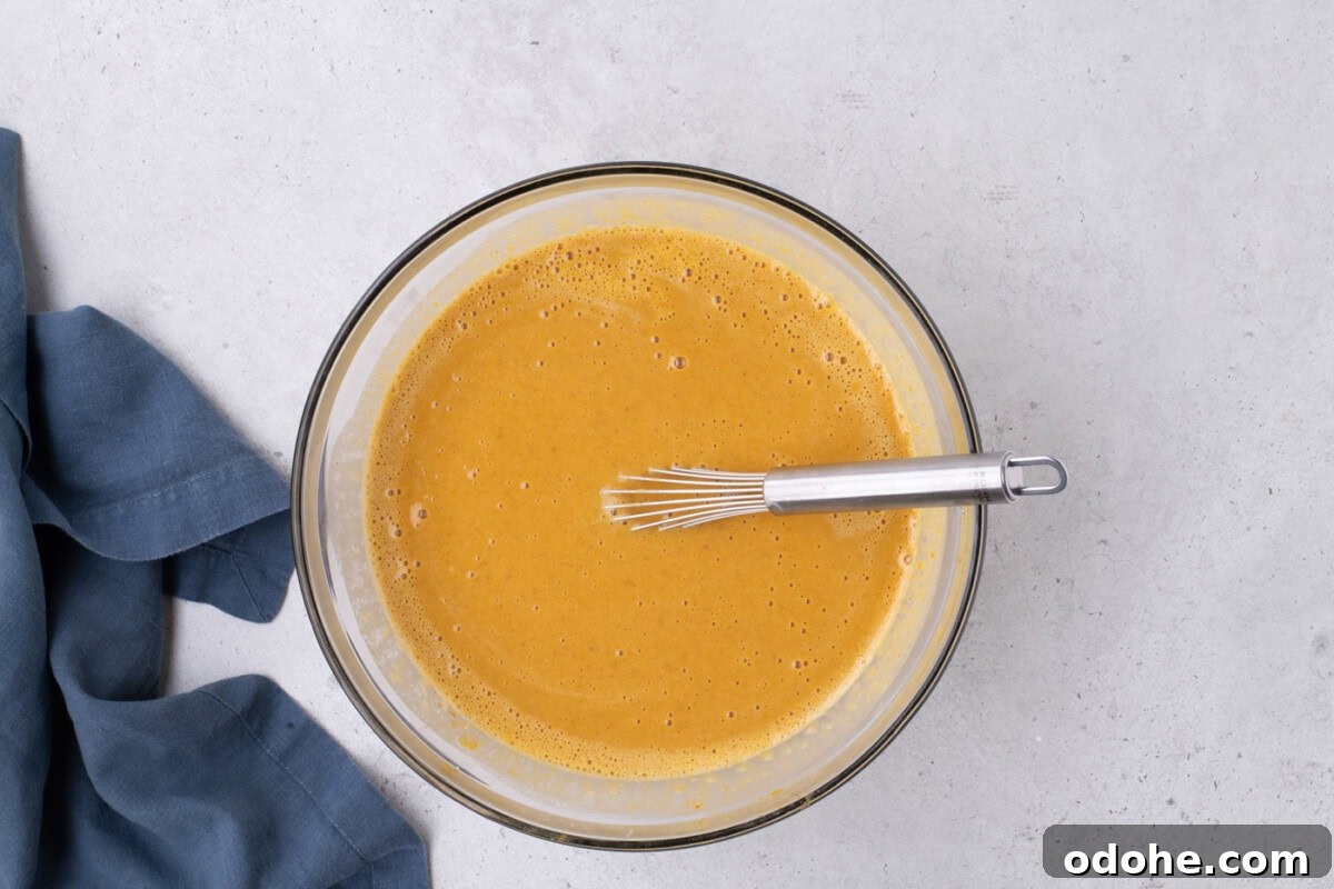Giant Pumpkin Slab Pie Recipe for Fall Gatherings 12 whisked pumpkin pie filling in a bowl