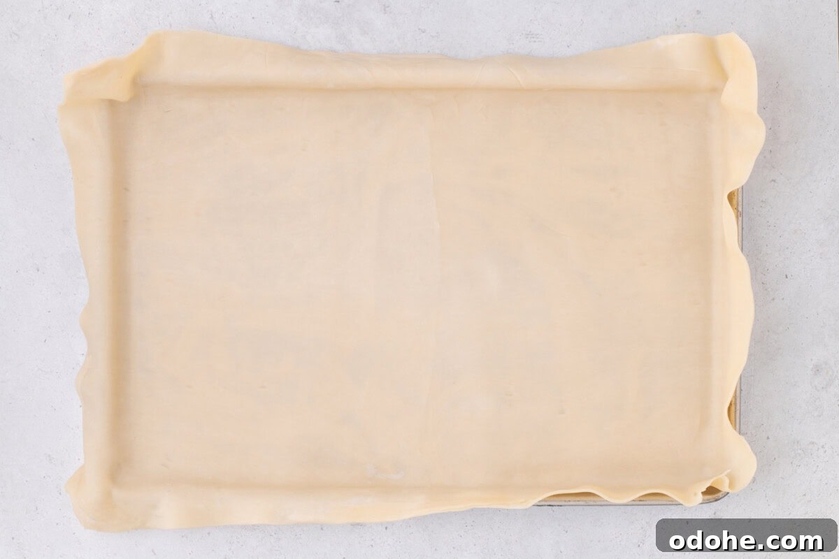 Giant Pumpkin Slab Pie Recipe for Fall Gatherings 8 pie crust draping over a jelly roll pan