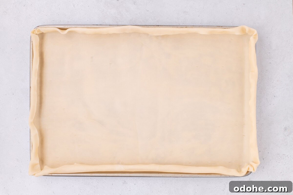 Giant Pumpkin Slab Pie Recipe for Fall Gatherings 9 pie dough folded over edges of jelly roll pan