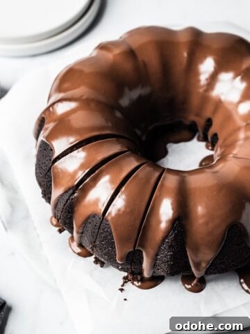 Close up of sliced bundt cake on a white marble background