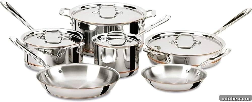 A set of stainless steel and copper pots and pans with stainless steel lids. 