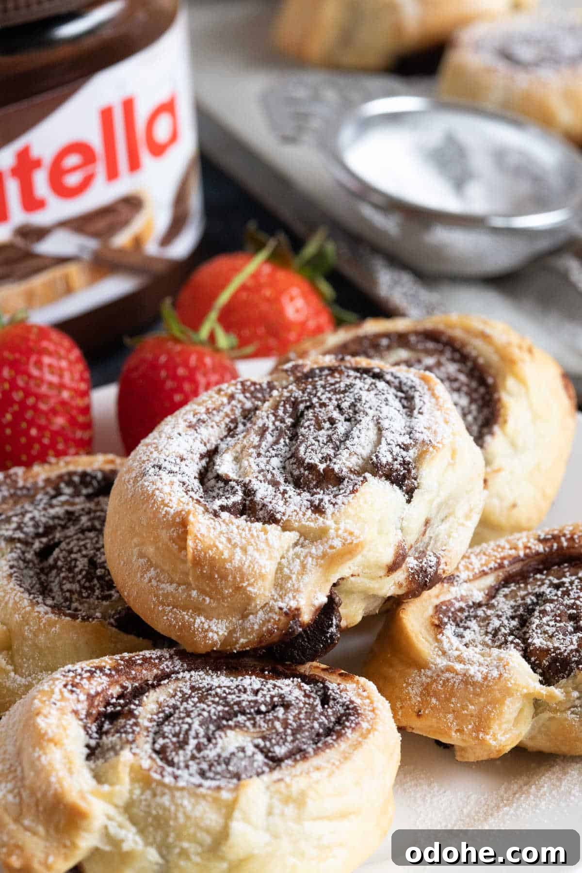 Nutella swirls piled onto a plate with a jar of Nutella in the background.