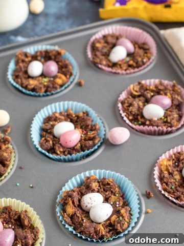 Chocolate cornflake cakes in a muffin pan with mini eggs.