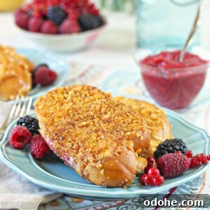 Mascarpone Rhubarb Stuffed French Toast on a blue plate with fresh berries around.