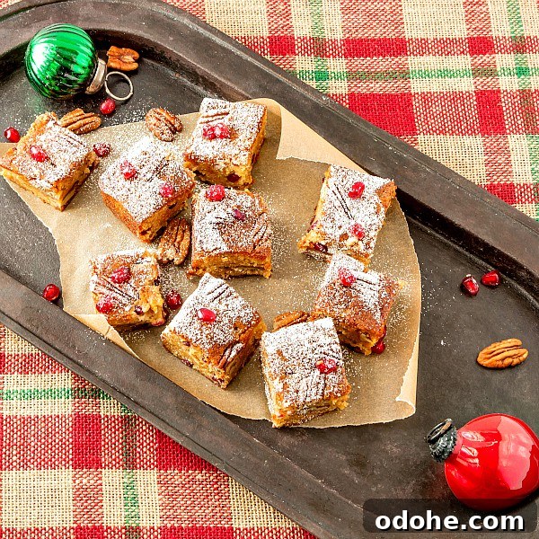Christmas Sorghum Blondies with Pomegranate & Pecans Recipe 2 A platter of blondies with pecans and pomegranate arils and Christmas decorations.