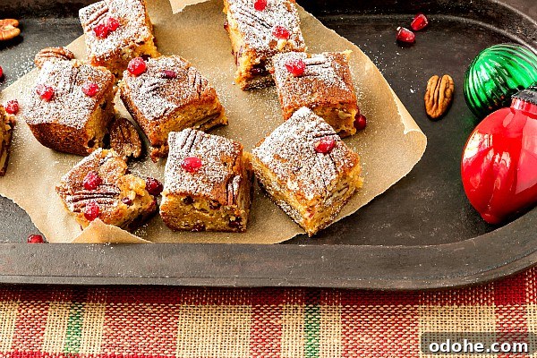 Christmas Sorghum Blondies with Pomegranate & Pecans Recipe 4 Sorghum blondies on brown parchment paper on a platter.