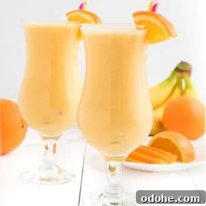 Two glasses of orange smoothie side by side.