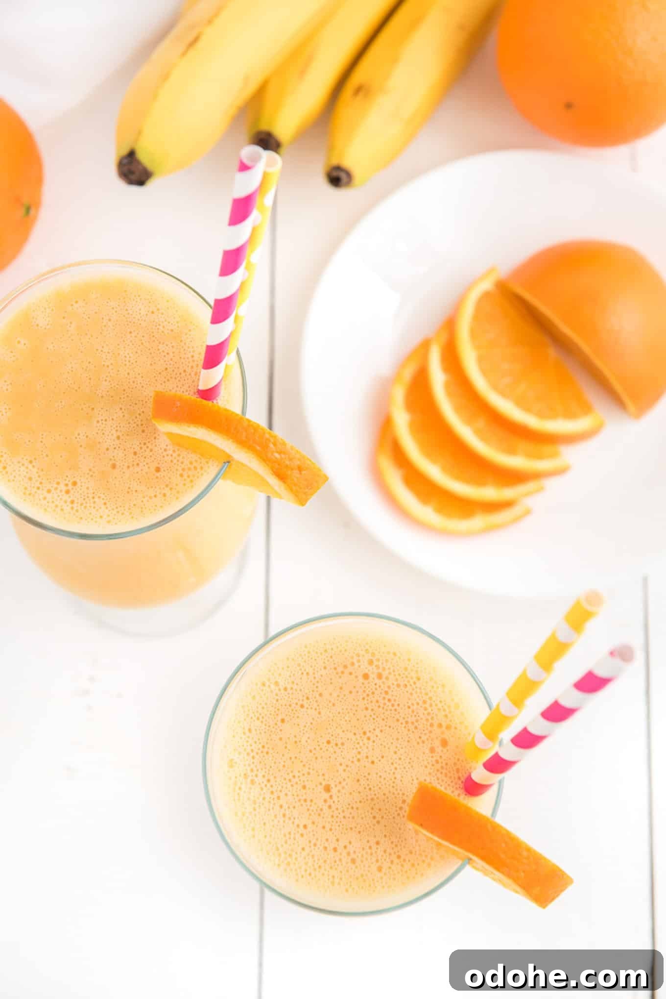 Energizing Orange Smoothie Recipe for Vitamin C Boost 5 Above shot of two orange smoothie drinks surrounded by the key ingredients.