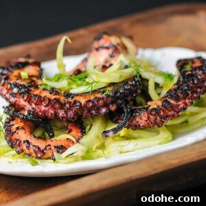 Grilled Octopus Salad with Tangy Citrus Vinaigrette 3 grilled octopus on a bed of greens.