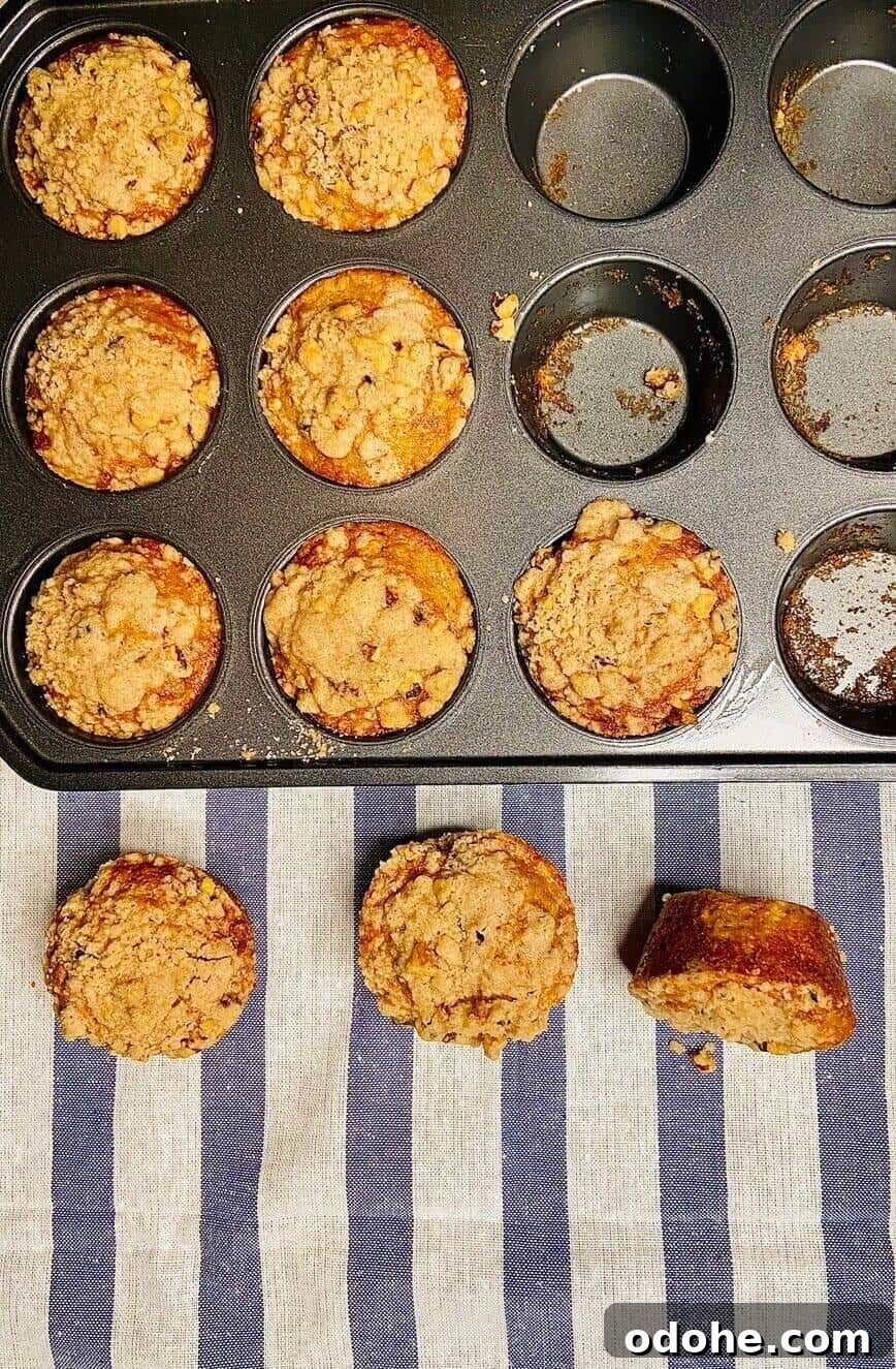Baked muffins in pan, with three taken out and placed on table.