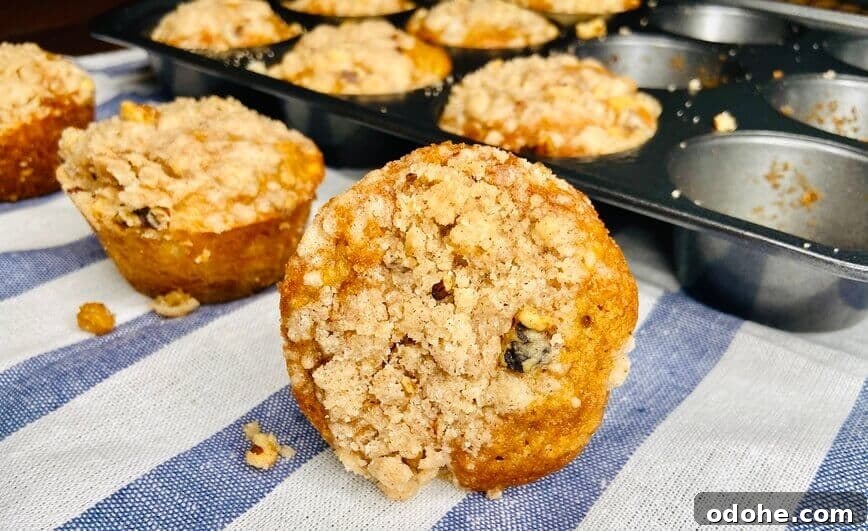 Some muffins on a blue and white striped towel, in front of the baking pan.
