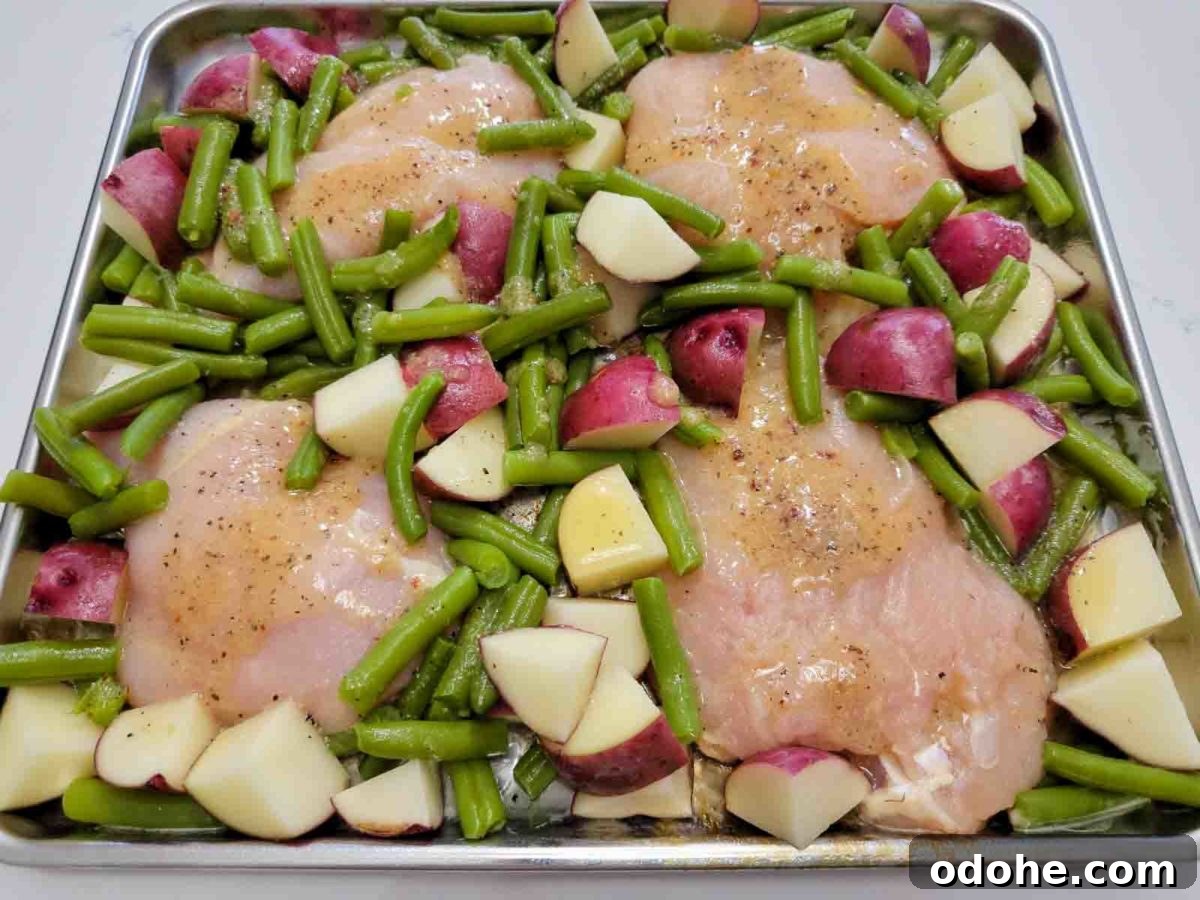 Italian Sheet-Pan Dinner: Simple One-Pan Tray Bake Recipe 6 italian dressing chicken on a sheet pan filled with boneless chicken, red potatoes and green beans.