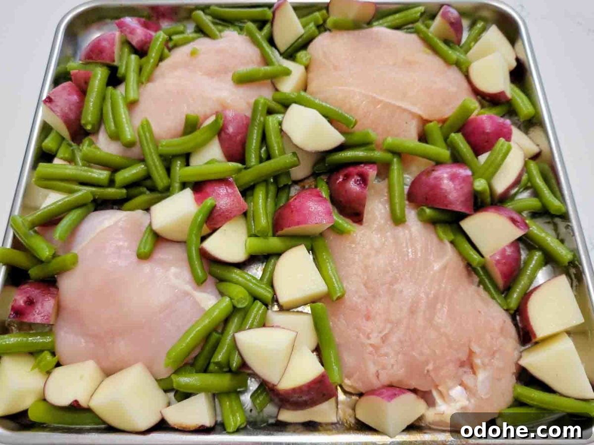 Italian Sheet-Pan Dinner: Simple One-Pan Tray Bake Recipe 4 a sheet pan filled with italian tray bake with boneless chicken, red potatoes and green beans.