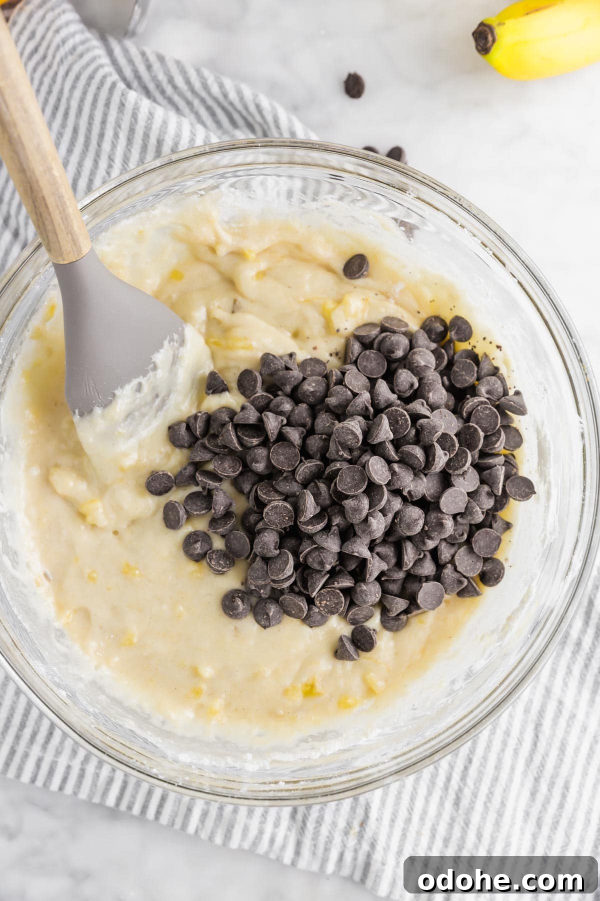 Gluten-Free Vegan Banana Chocolate Chip Muffins Recipe 5 A bowl of banana muffin batter with chocolate chips added in.