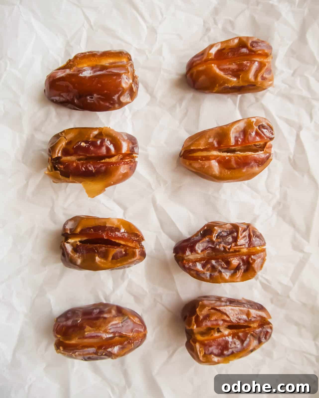 Bacon-Wrapped Raspberry-Stuffed Dates | Paleo & Whole30-Friendly 5 Dates on a cookie sheet.