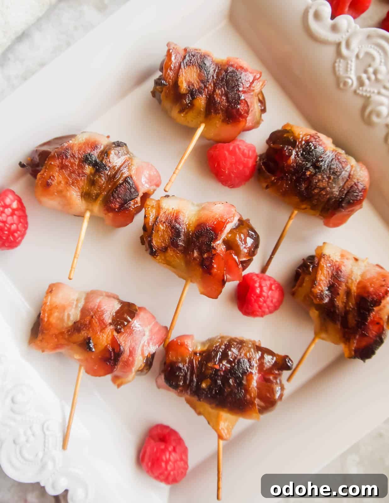 Bacon-Wrapped Raspberry-Stuffed Dates | Paleo & Whole30-Friendly 8 Freshly cooked raspberry stuffed dates wrapped in crispy bacon.