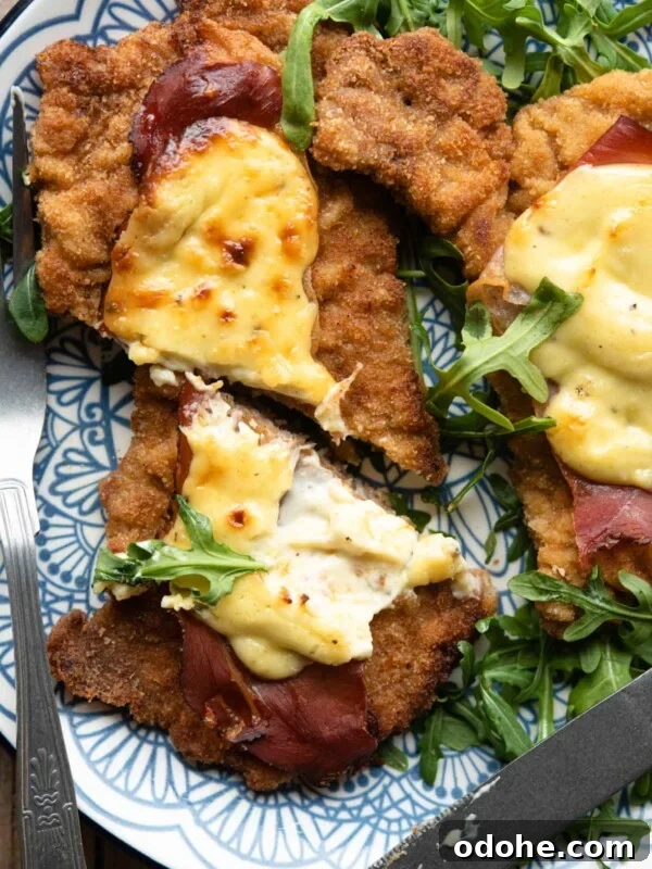 Chicken Saltimbocca Recipe: Tender Prosciutto-Wrapped Chicken with Sage 11 A close up of a veal cutlet cut in half with parmesan cream and prosciutto on top