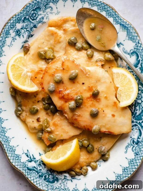 Chicken Saltimbocca Recipe: Tender Prosciutto-Wrapped Chicken with Sage 10 An overhead shot of chicken piccata on a blue serving plate with lemon wedges and capers