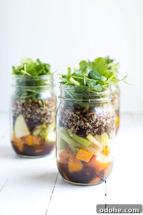 Fall Mason Jar Salad with Maple Balsamic Dressing includes roasted butternut squash, apples, dried cranberries, quinoa, toasted pumpkin seeds, and fresh greens!