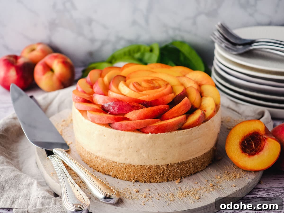 No-Bake Cheesecake Recipes: Simple, No-Oven Dessert Ideas 28 Peach cheesecake with fresh peach rose on a serving board, with a pile of plates and forks in the background.
