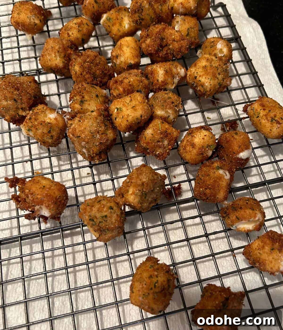 Crispy Fried Mozzarella Balls with Marinara Dip 10 Fried cheese on baking rack over paper towels.