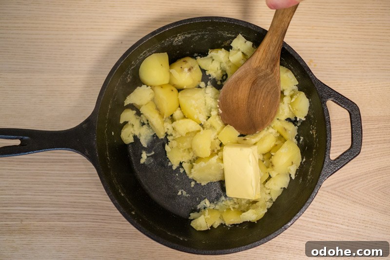 Adding the butter to the potatoes