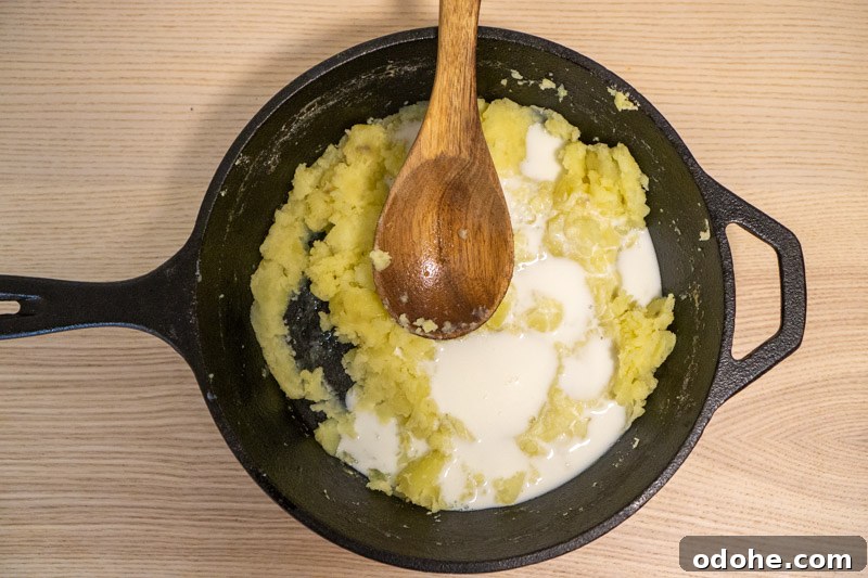 Adding the milk and buttermilk to the potatoes