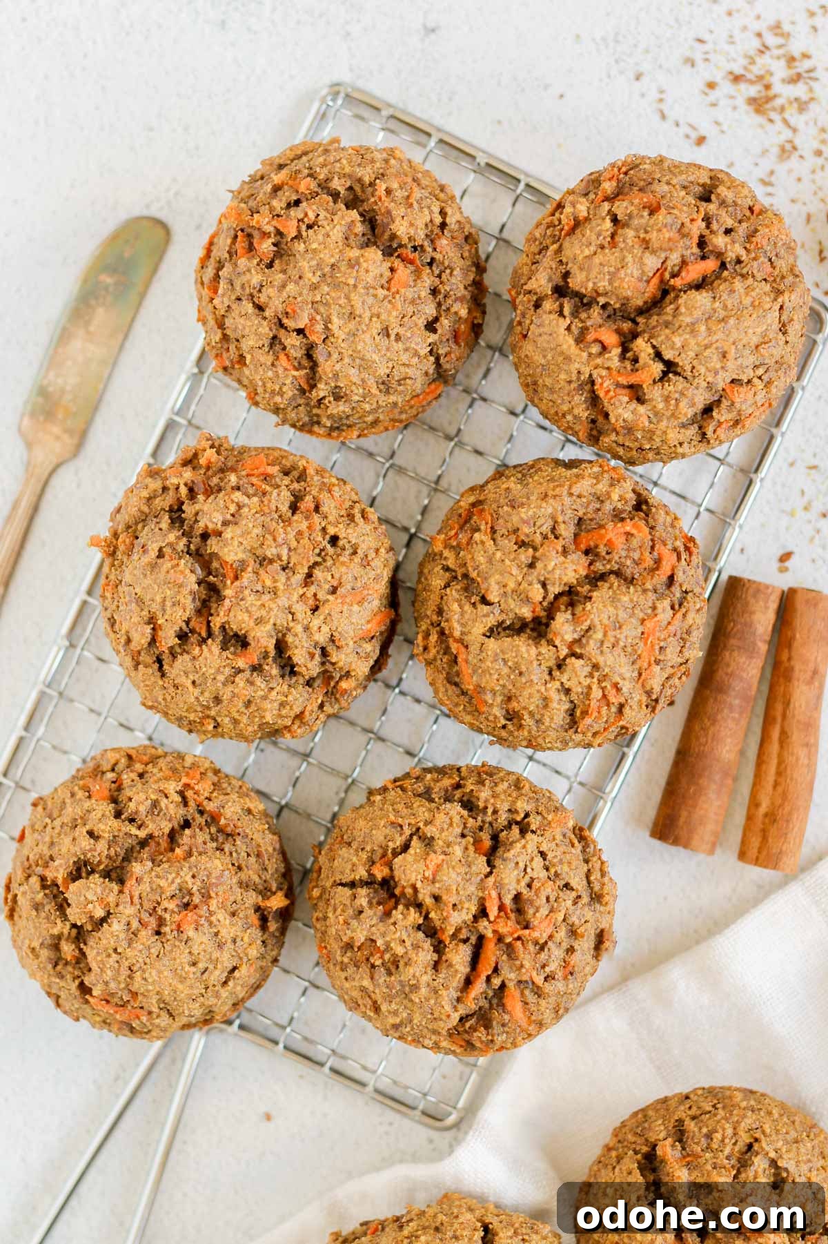 Flaxseed Carrot Muffins with Cinnamon and Honey 2 Six carrot flaxseed muffins on a rectangular wire cooling rack with a vintage butter knife on the side.