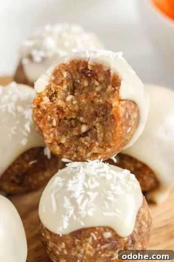 Carrot cake ball topped with glaze bit in half to show texture.