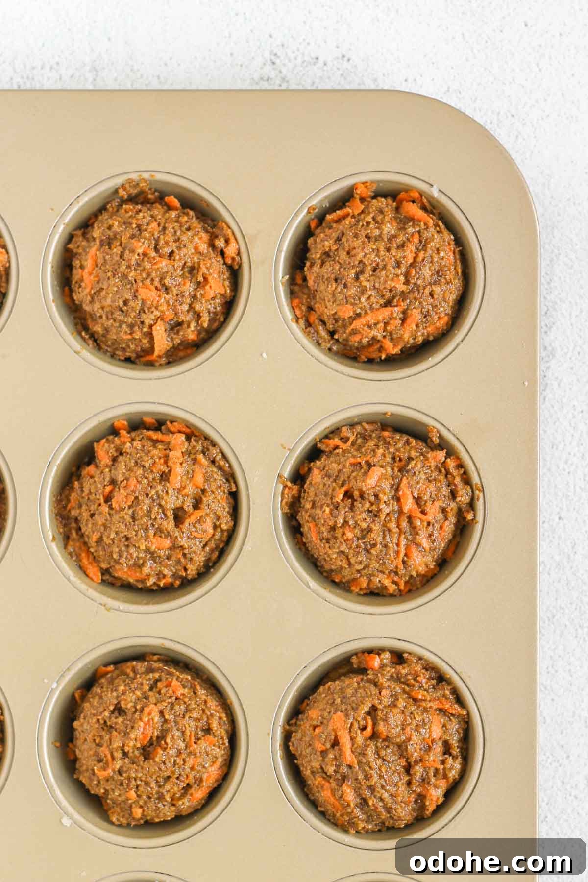 Flaxseed Carrot Muffins with Cinnamon and Honey 7 Carrot flaxseed muffin batter scooped into a muffin tin.