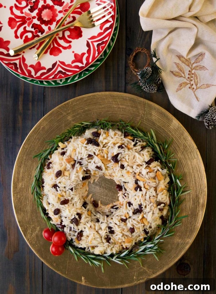 Christmas rice shaped like a wreath on a golden plate with berries and greens