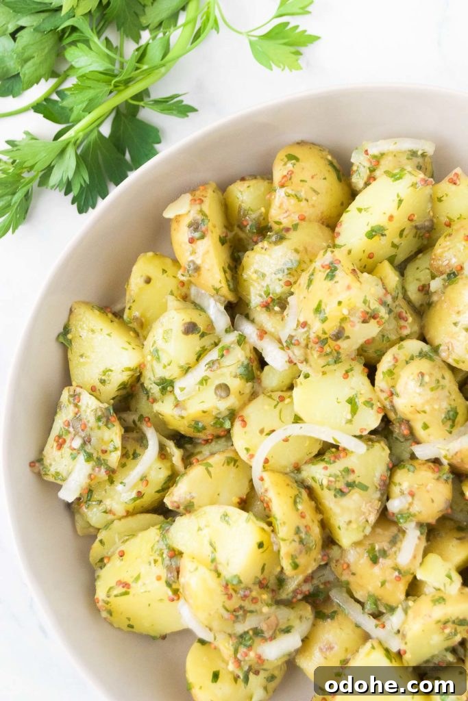 Vegan potato salad in a bowl next to fresh parsley