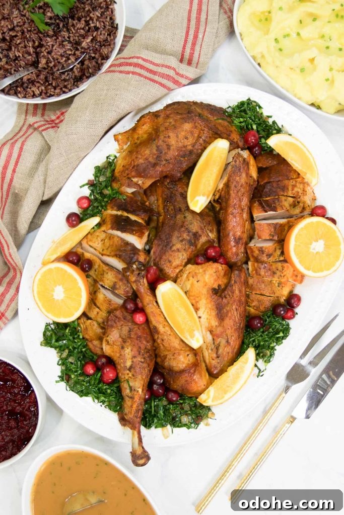 Pieces of a dry brine spatchcock turkey on a platter with greens