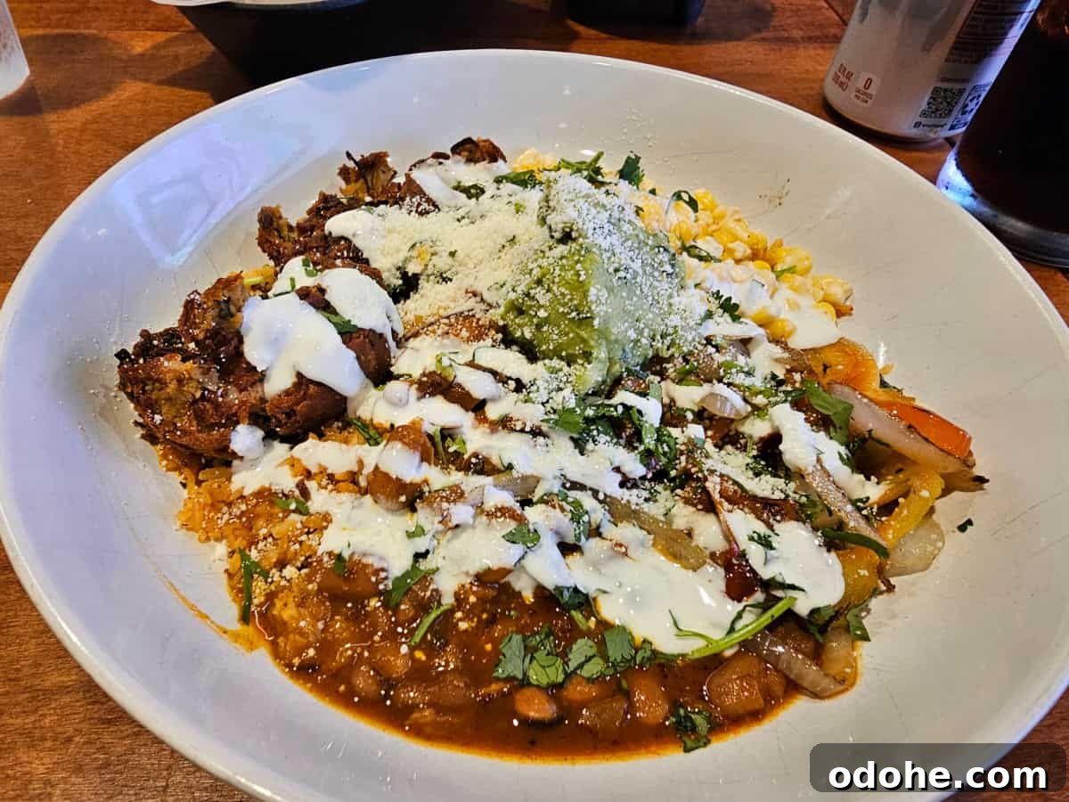 pinto bean falafel fajita bowl in a white bowl next to a drink
