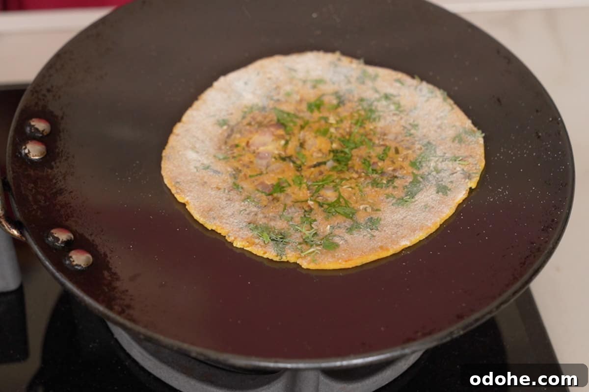 Roti transferred to hot tawa and tawa flipped upside down.