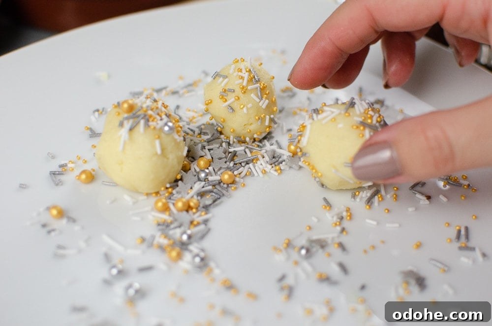 Decadent White Chocolate Truffles Recipe for Homemade Gifts 11 Rolling the white chocolate truffles in silver,white and gold sprinkles on a white plate