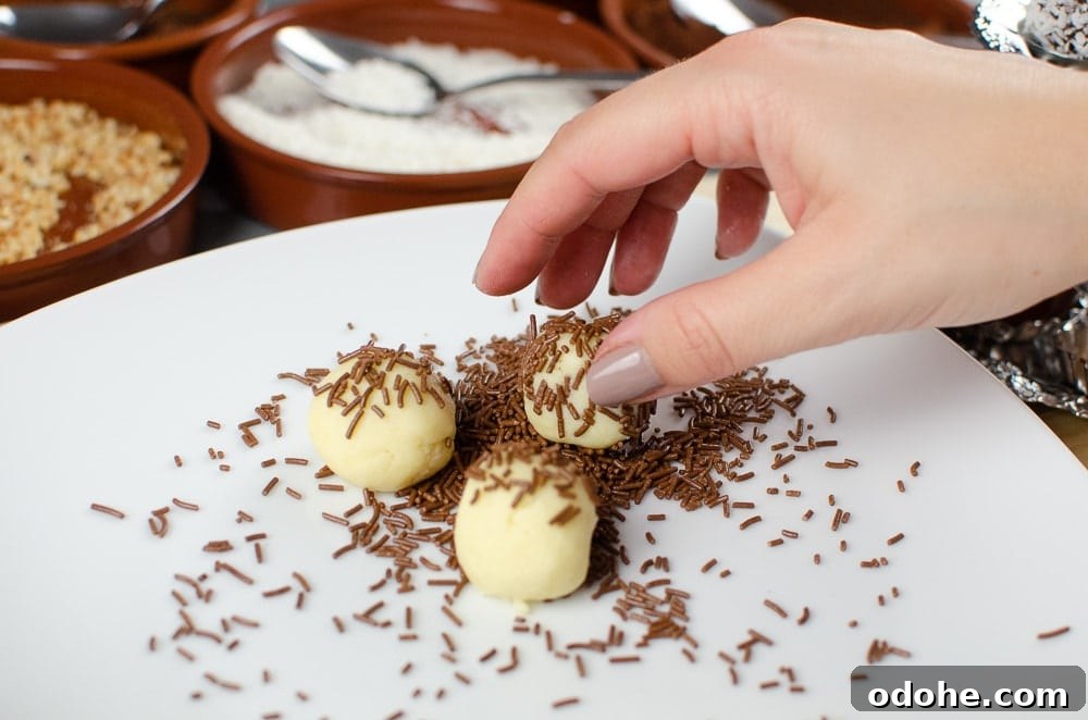 Decadent White Chocolate Truffles Recipe for Homemade Gifts 10 Rolling the white chocolate truffles in chocolate sprinkles on a white plate
