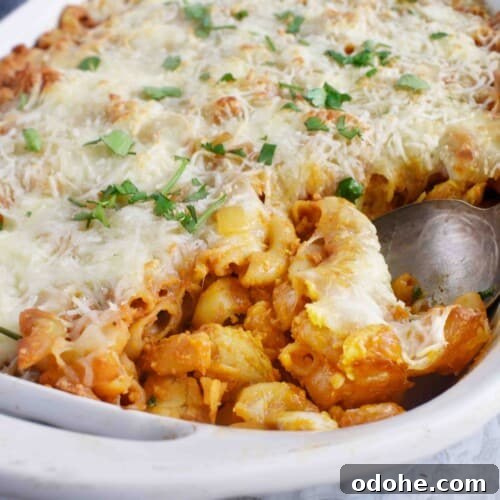 spoon in baking dish scooping out mac and cheese