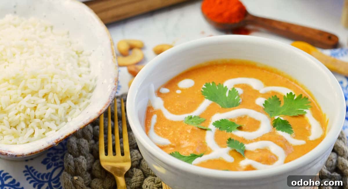 individual bowl of butter chicken and rice with gold fork.