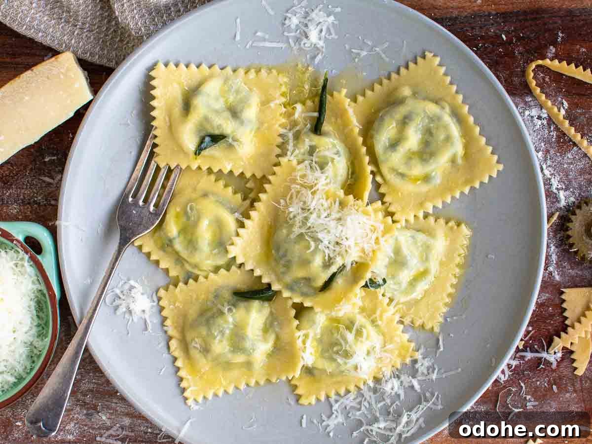 Fresh Spinach and Ricotta Ravioli Recipe for Homemade Pasta 16 Overhead view of spinach ravioli on a plate with a fork and cheese grated on top.