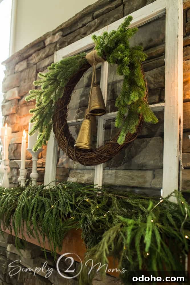 13 Timeless Neutral Christmas Decorating Ideas for Your Home 12 antique window with wreath and bells hanging on it sitting on wood fireplace mantel with greenery along mantel