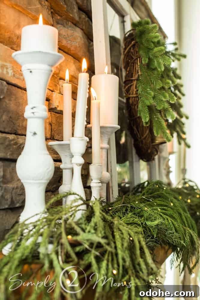13 Timeless Neutral Christmas Decorating Ideas for Your Home 10 close up of candlesticks on wood fireplace mantel with garland and greenery