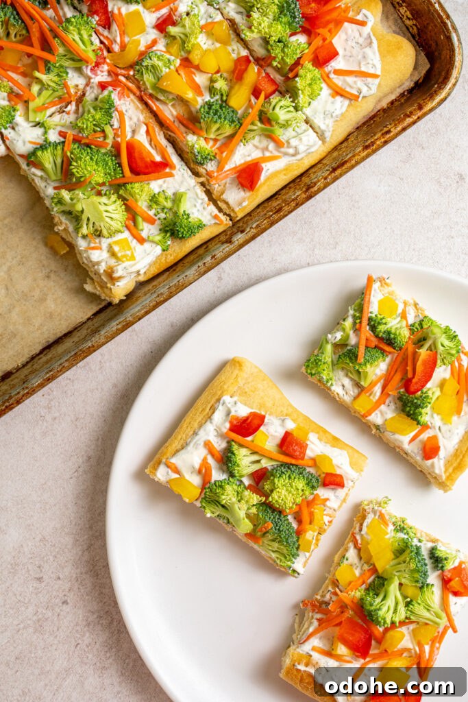 Overhead view of the sheet pan and white plate with slices of cold veggies pizza on them.