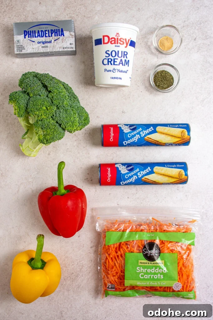 Ingredients needed to make crescent roll veggie pizza laid out on a table top.