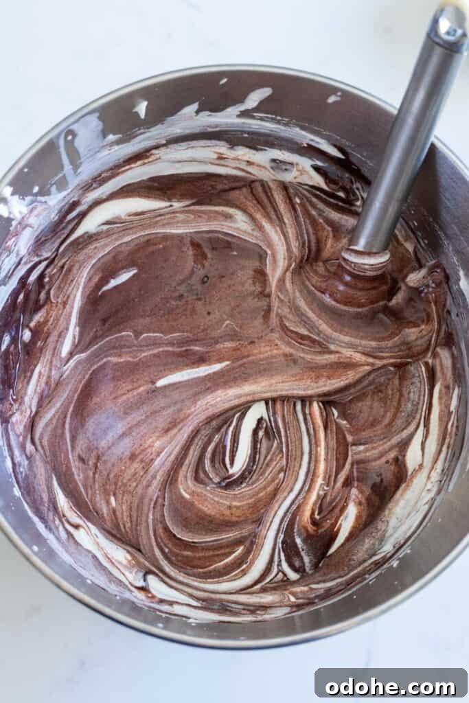 chocolate no-churn ice cream being stirred in metal bowl