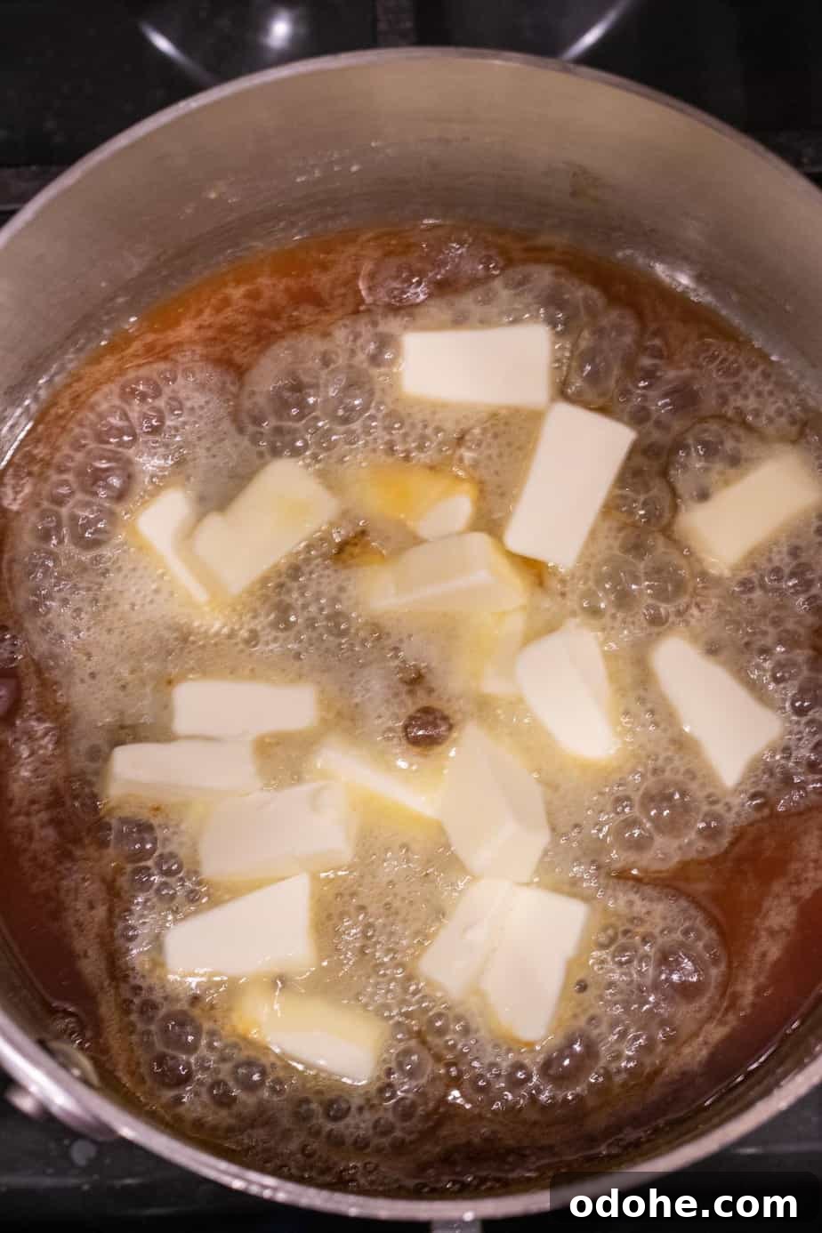 cubed butter in melted sugar in saucepan