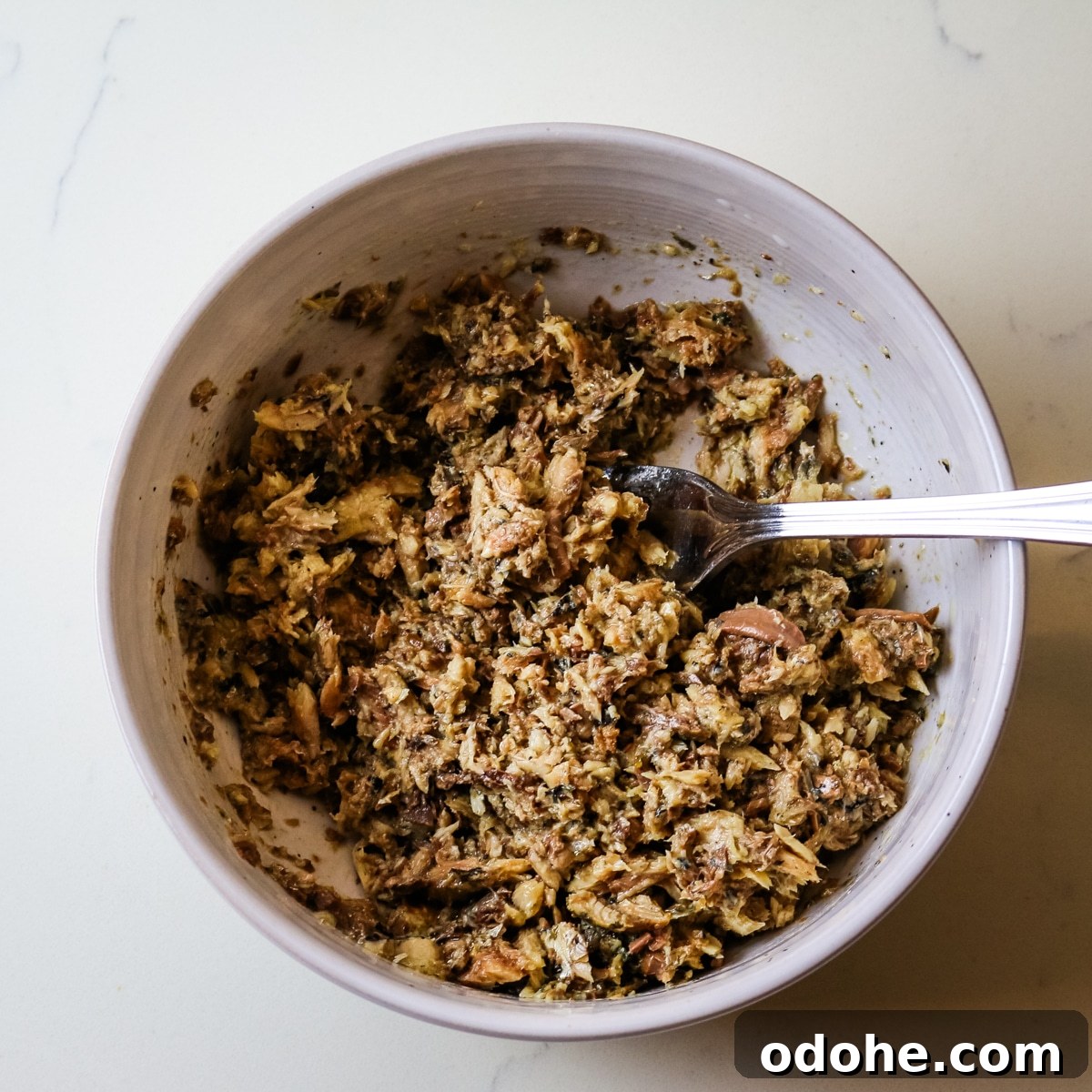 Sardine and Egg Toast Recipe for Brunch or Quick Meals 8 Shredded sardines in a white bowl with a fork in it.